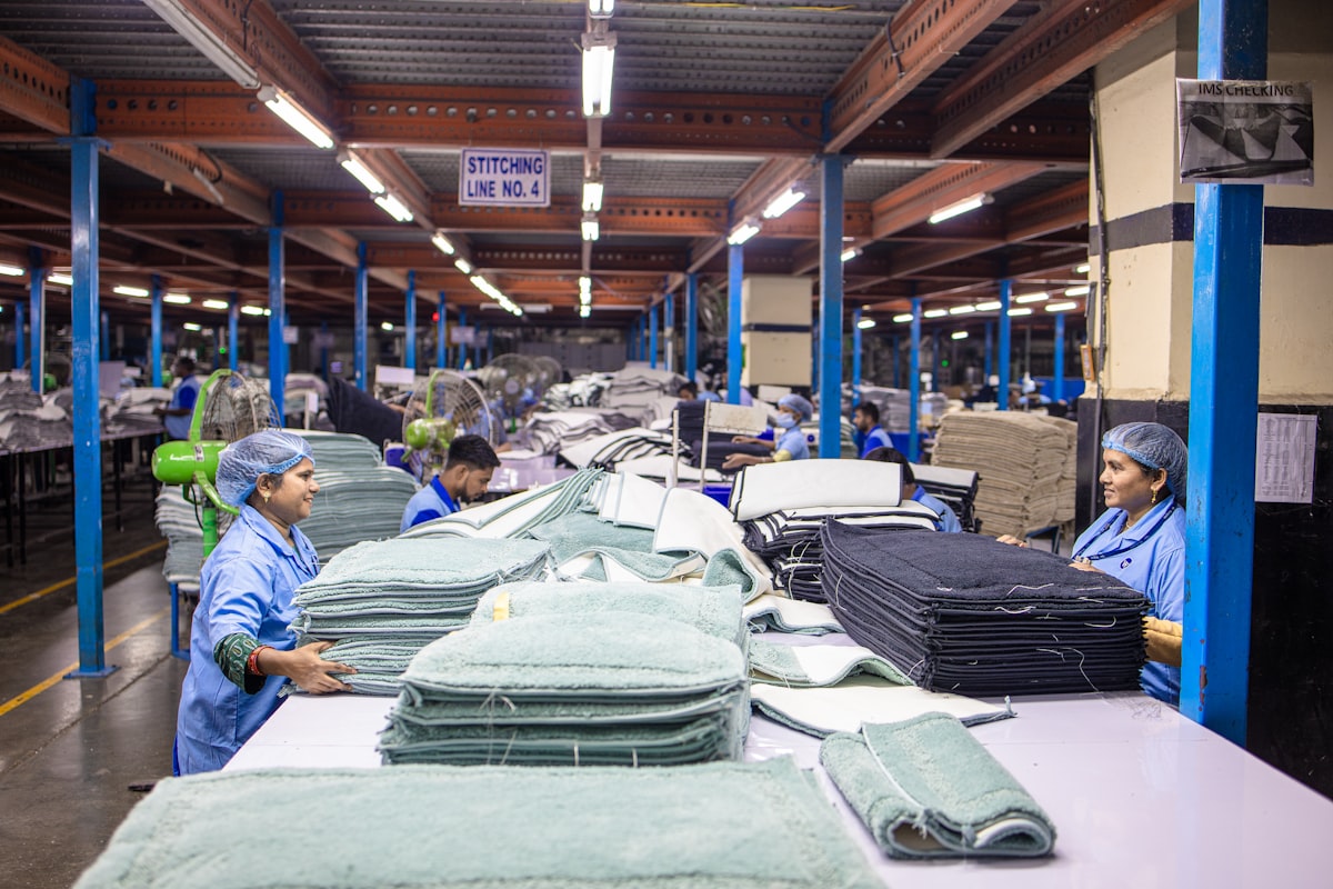Workers folding and stacking finished garments on a factory table
